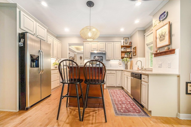 2975 Pine Edge Ct, Holland, MI 49424 - kitchen featuring appliances with stainless steel finishes, open shelves, ornamental molding, a center island, and a breakfast bar area