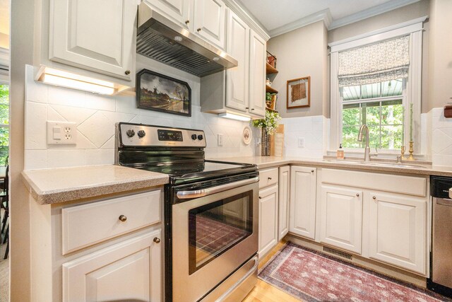 2975 Pine Edge Ct, Holland, MI 49424 - kitchen featuring appliances with stainless steel finishes, under cabinet range hood, ornamental molding, light countertops, and tasteful backsplash