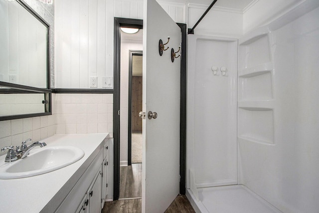 51591 Oak Dr, Mattawan, MI 49071 - bathroom featuring wood finished floors, vanity, a shower, and backsplash