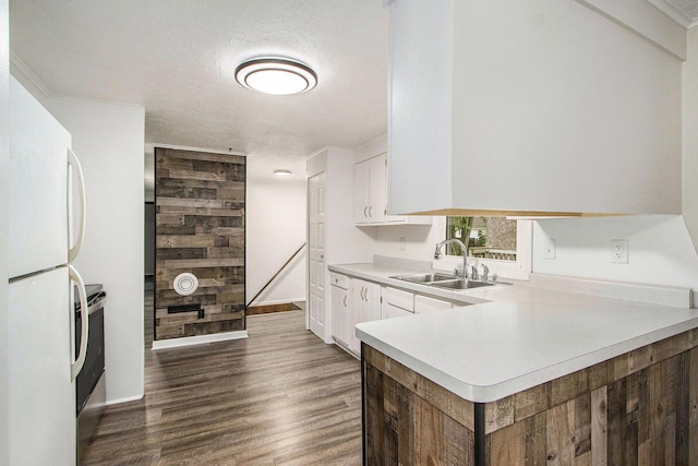 51591 Oak Dr, Mattawan, MI 49071 - kitchen with freestanding refrigerator, light countertops, white cabinets, dark wood finished floors, and a peninsula