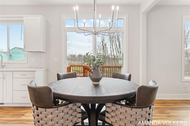 1753 Portadown Rd, Byron Center, MI 49315 - dining area featuring a chandelier, light wood finished floors, and healthy amount of natural light
