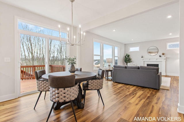 1753 Portadown Rd, Byron Center, MI 49315 - dining area featuring light wood finished floors, a chandelier, a fireplace, and recessed lighting