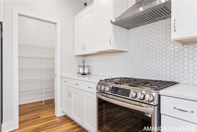 1753 Portadown Rd, Byron Center, MI 49315 - kitchen with stainless steel range with gas cooktop, wall chimney exhaust hood, light countertops, and white cabinets