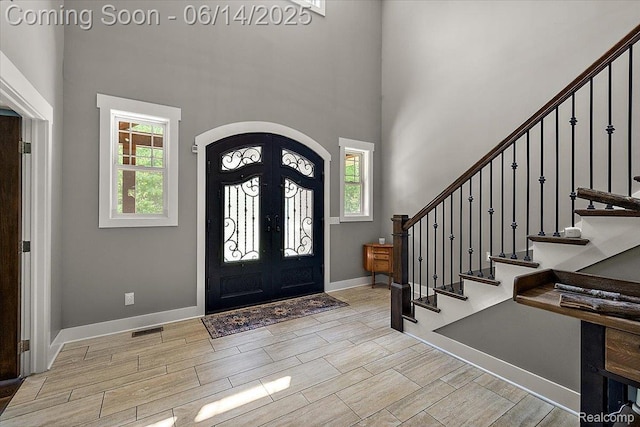 5432 Blood Rd, Metamora, MI 48455 - entryway featuring arched walkways, plenty of natural light, stairs, wood tiled floors, and a high ceiling