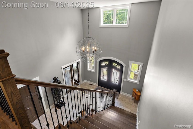 5432 Blood Rd, Metamora, MI 48455 - entryway with french doors, wood finished floors, a chandelier, stairway, and a towering ceiling