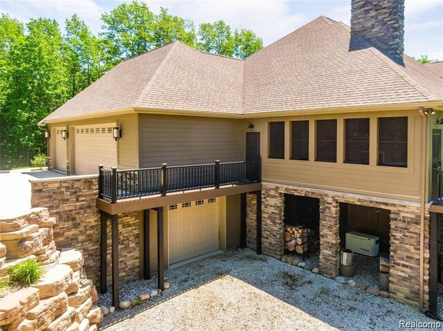 5432 Blood Rd, Metamora, MI 48455 - view of front of home featuring a garage, a chimney, driveway, a shingled roof, and stone siding