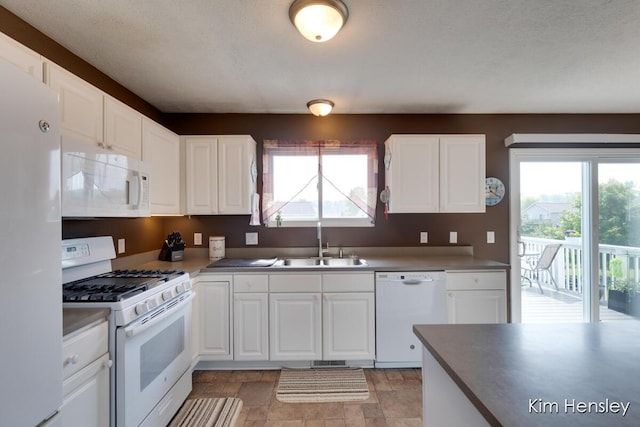 7088 Quintara Dr NE, Comstock Park, MI 49321 - kitchen featuring white appliances, healthy amount of natural light, light stone finish floors, and white cabinetry
