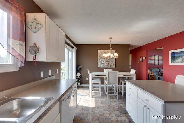 7088 Quintara Dr NE, Comstock Park, MI 49321 - kitchen with dishwasher, stone finish floors, white cabinets, a chandelier, and decorative light fixtures