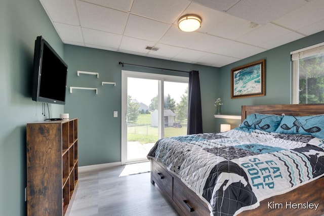 7088 Quintara Dr NE, Comstock Park, MI 49321 - bedroom featuring a drop ceiling, access to exterior, multiple windows, and wood finished floors