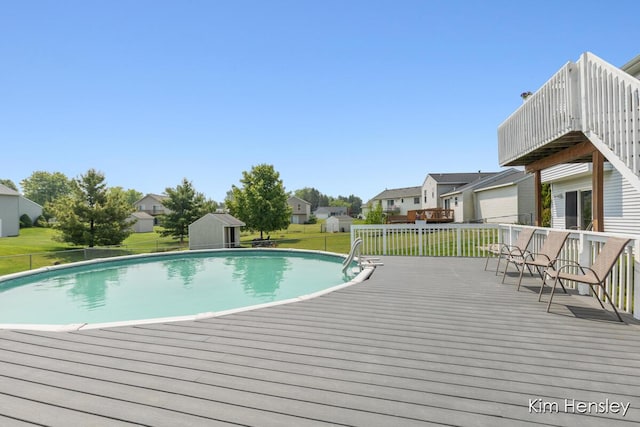 7088 Quintara Dr NE, Comstock Park, MI 49321 - outdoor pool featuring a deck, a residential view, a lawn, and a shed