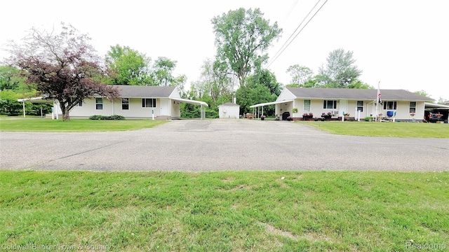 57035 Bonne Terre, New Hudson, MI 48165 - view of front of home featuring asphalt driveway, a front lawn, a carport, and a shed