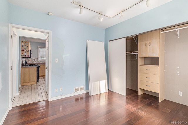 92 Gallup St, Mount Clemens, MI 48043 - unfurnished bedroom featuring rail lighting, wood finished floors, and a closet