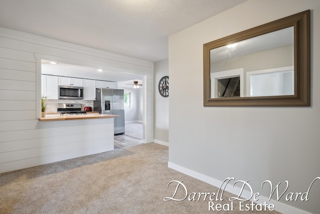 612 E Green St, Hastings, MI 49058 - kitchen with stainless steel appliances, white cabinetry, light carpet, a peninsula, and wooden counters