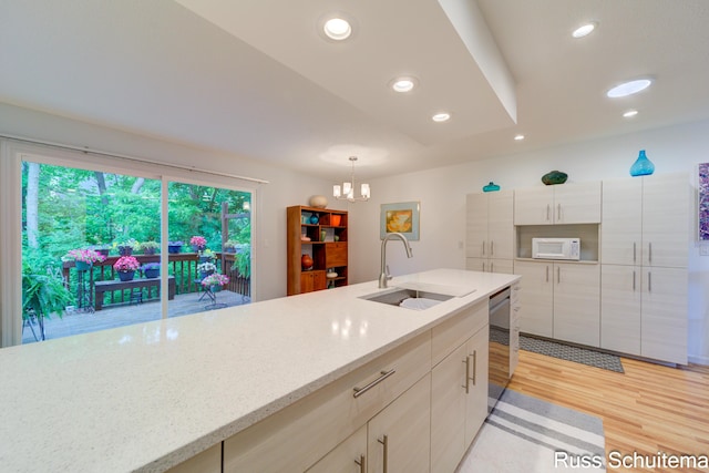 1366 W Norton Ave, Muskegon, MI 49441 - kitchen featuring white microwave, a chandelier, light wood-type flooring, dishwasher, and hanging light fixtures