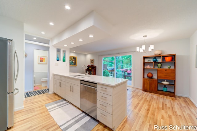 1366 W Norton Ave, Muskegon, MI 49441 - kitchen with appliances with stainless steel finishes, a peninsula, light wood-style flooring, light countertops, and recessed lighting