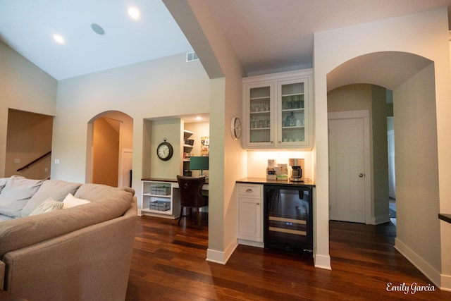 14921 Creek Edge Dr, Holland, MI 49424 - living room featuring beverage cooler, a bar, arched walkways, dark wood-style flooring, and recessed lighting