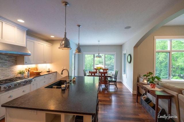 14921 Creek Edge Dr, Holland, MI 49424 - kitchen with arched walkways, dark countertops, stainless steel gas stovetop, dark wood finished floors, and recessed lighting