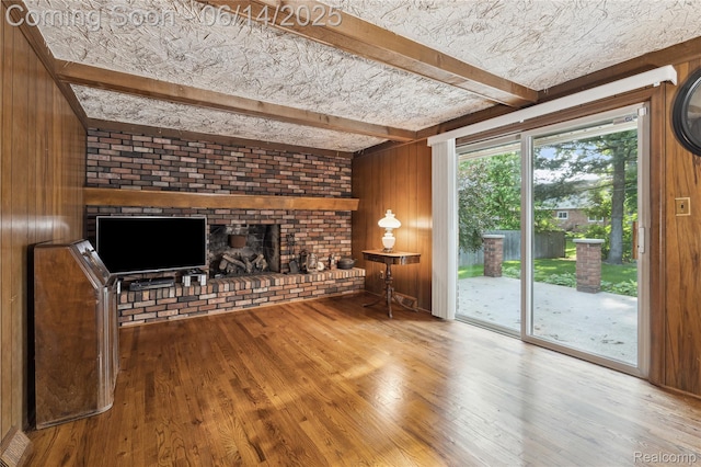 5614 Warbler Dr, Clarkston, MI 48346 - unfurnished living room with wooden walls, a fireplace, wood finished floors, and beamed ceiling