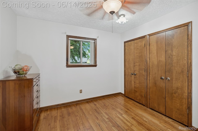 5614 Warbler Dr, Clarkston, MI 48346 - unfurnished bedroom featuring light wood finished floors, a textured ceiling, two closets, and a ceiling fan