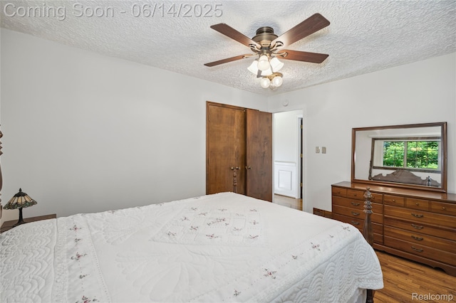 5614 Warbler Dr, Clarkston, MI 48346 - bedroom featuring wood finished floors, a textured ceiling, a closet, and ceiling fan