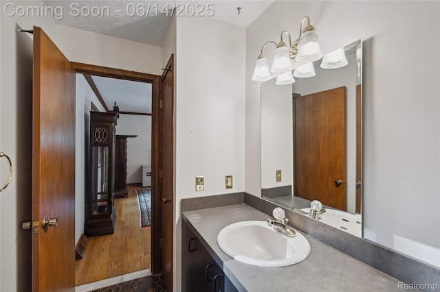 5614 Warbler Dr, Clarkston, MI 48346 - bathroom with vanity, a chandelier, and wood finished floors