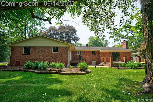 5614 Warbler Dr, Clarkston, MI 48346 - back of property with a chimney, brick siding, and a yard
