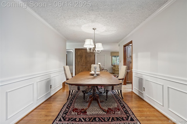 5614 Warbler Dr, Clarkston, MI 48346 - dining room featuring a decorative wall, a chandelier, ornamental molding, light wood-type flooring, and a wainscoted wall