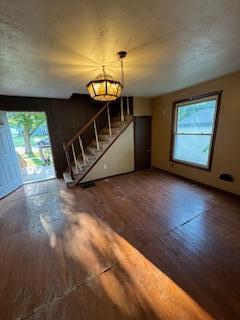 313 Morse St, Ionia, MI 48846 - unfurnished living room featuring hardwood / wood-style floors and stairs
