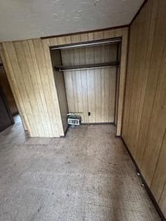 313 Morse St, Ionia, MI 48846 - unfurnished bedroom featuring wood walls