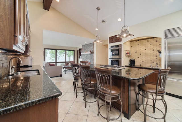 3524 Lakeshore Rd, Manistee, MI 49660 - kitchen with appliances with stainless steel finishes, a kitchen bar, decorative backsplash, high vaulted ceiling, and beamed ceiling