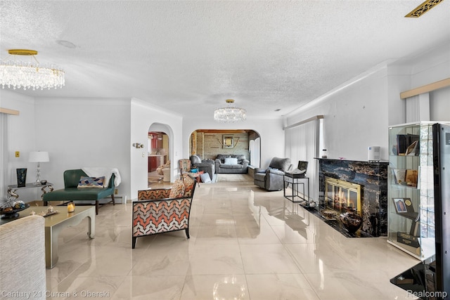 7561 Esper Blvd, Dearborn, MI 48126 - living area featuring arched walkways, a chandelier, a textured ceiling, a fireplace, and crown molding
