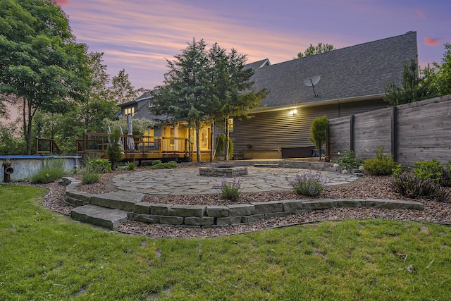 3778 22nd St, Dorr, MI 49323 - back of house at dusk with a wooden deck, a patio, a swimming pool, and roof with shingles