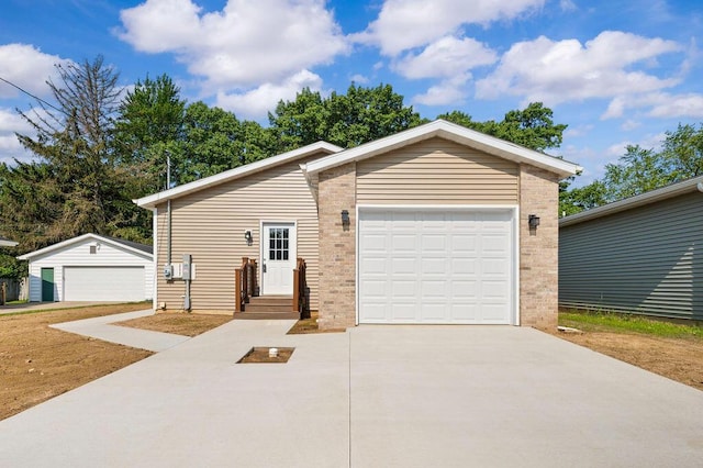 310 Hillview St, Buchanan, MI 49107 - view of front of house with concrete driveway, brick siding, a garage, and an outdoor structure