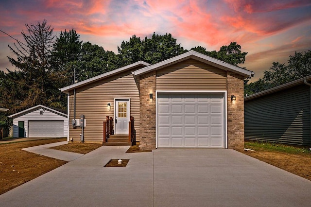 310 Hillview St, Buchanan, MI 49107 - view of front of house with concrete driveway, a garage, and an outbuilding