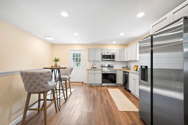 310 Hillview St, Buchanan, MI 49107 - kitchen featuring stainless steel appliances, wood-type flooring, light countertops, backsplash, and recessed lighting