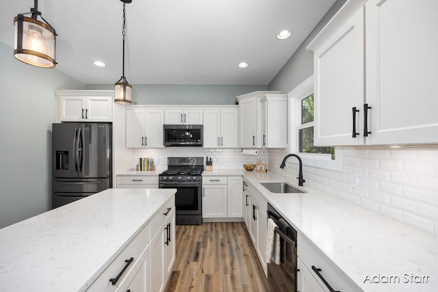 3980 Hathaway Rd, Kalamazoo, MI 49009 - kitchen featuring appliances with stainless steel finishes, white cabinets, decorative backsplash, light stone countertops, and recessed lighting