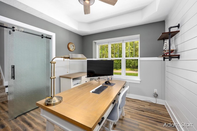 3980 Hathaway Rd, Kalamazoo, MI 49009 - home office with dark wood-style floors, a ceiling fan, a tray ceiling, and wood walls