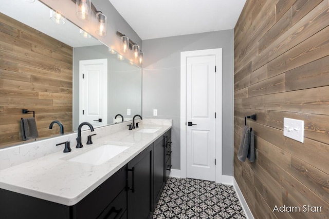 3980 Hathaway Rd, Kalamazoo, MI 49009 - bathroom featuring wooden walls, double vanity, tile patterned floors, and an accent wall