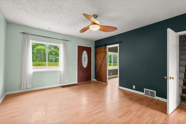 524 Kiddville St, Belding, MI 48809 - entryway with a barn door, plenty of natural light, a ceiling fan, wood finished floors, and a textured ceiling