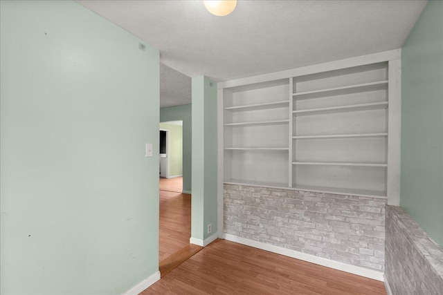 524 Kiddville St, Belding, MI 48809 - unfurnished room featuring a textured ceiling, wood finished floors, and built in features
