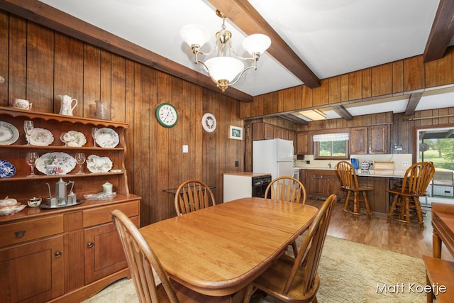 4410 Delaware Rd, Fremont, MI 49412 - dining space featuring wood walls, beam ceiling, a chandelier, and light wood-type flooring