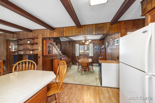 4410 Delaware Rd, Fremont, MI 49412 - dining space with wood walls, light wood finished floors, beamed ceiling, and stairway