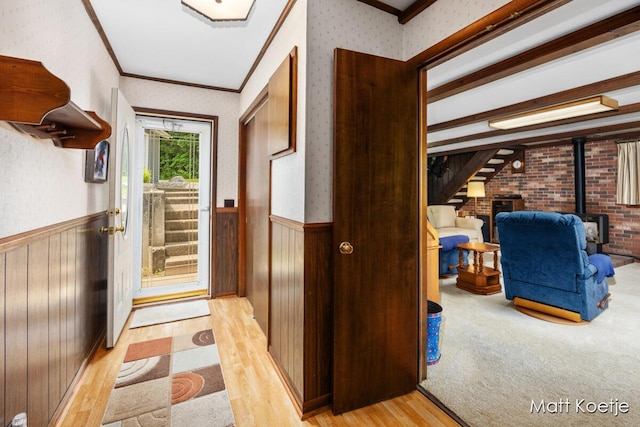4410 Delaware Rd, Fremont, MI 49412 - doorway featuring a wood stove, wallpapered walls, wainscoting, light wood finished floors, and crown molding