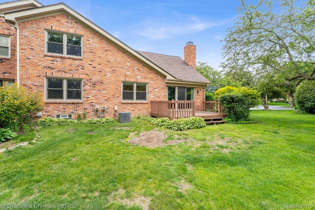 3 Cornell Ct Unit 27, Dearborn, MI 48124 - rear view of house featuring brick siding, a wooden deck, a chimney, and a lawn