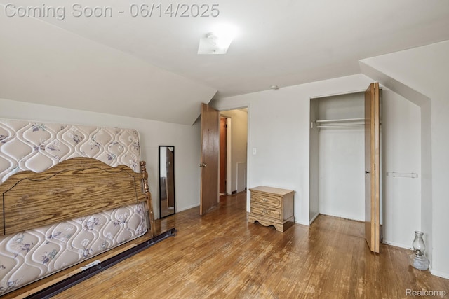 37649 Castle Dr, Romulus, MI 48174 - bedroom featuring wood finished floors, a closet, and vaulted ceiling
