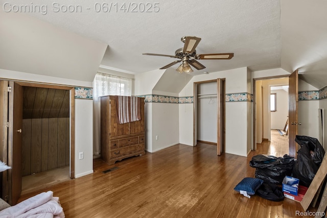 37649 Castle Dr, Romulus, MI 48174 - unfurnished bedroom with wood finished floors, a textured ceiling, vaulted ceiling, and ceiling fan