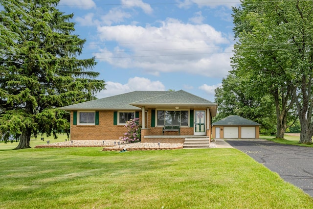 10001 Date Rd, Baroda, MI 49101 - view of front facade featuring brick siding, an outbuilding, a detached garage, a front lawn, and a shingled roof
