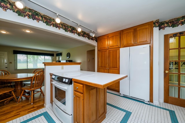 10001 Date Rd, Baroda, MI 49101 - kitchen with white appliances, light countertops, light tile patterned floors, brown cabinets, and arched walkways