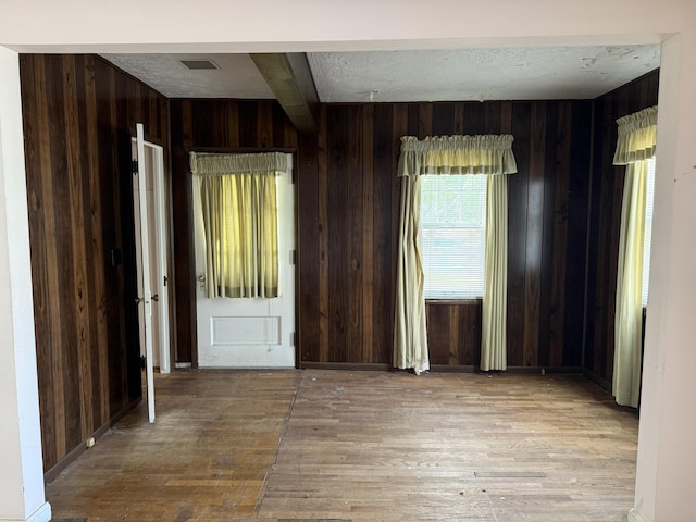 911 Napier Ave, Saint Joseph, MI 49085 - foyer entrance with hardwood / wood-style flooring, wood walls, beam ceiling, and a textured ceiling