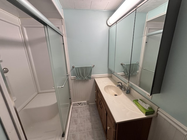 2523 E Wildcat, Saint Johns, MI 48879 - full bathroom featuring a wainscoted wall, a stall shower, vanity, and tile patterned floors
